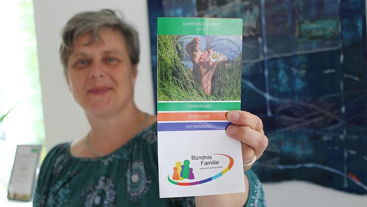 Projektkoordinatorin Lisa Kinalele hält den frisch gedruckten Programmflyer in der Hand. Foto: Julia Raab