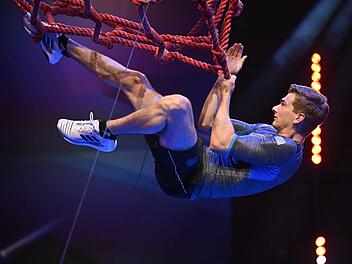 Hängt er nur in den Seilen oder drückt er  sogar den Buzzer? Kunstrad-Weltmeister Lukas Kohl nimmt in der Vorrunde an der TV-Show "Ninja Warrior" teil: Die Folge mit dem 24-Jährigen wird am Freitag um 20.15 Uhr auf RTL und im Stream bei TV Now ausgestrahlt. TV Now/Markus Hertrich