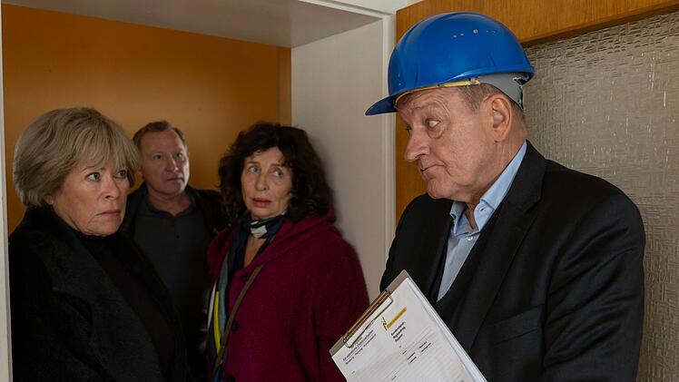 Wilsberg (Leonard Lansink, rechts) hat sich vor Hausbewohnerin Janne Becker (Teresa Harder, zweite von rechts) als Mitarbeiter des Bauamts ausgegeben. Als Anna Springer (Rita Russek) mit Overbeck (Roland Jankowsky) eintrifft, wird es ungem&uuml;tlich f&uuml;r Wilsberg.
