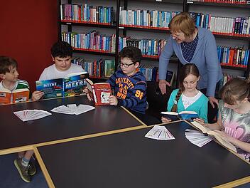 Simon Fritz, Mert Düzardic, Jakob Lux, Sophie Bechauf und Amelie Schreier (v. l.) schmökern in Büchern. Vor sich haben sie ihre Lese-Fächer "Textknacker" liegen. Mit im Bild ist Direktorin Renate Leive. Foto: Heike Schülein