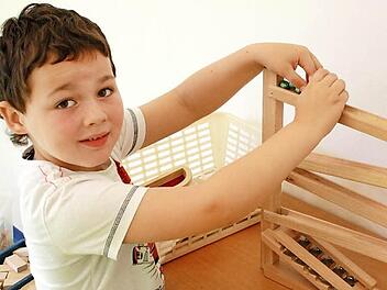 Daniel (5) spielt am liebsten mit der Murmelbahn. Er freut sich über mehr Platz und den neuen Turnraum. Fotos: Robert Huger