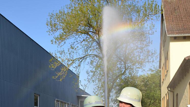 Der Stützkrümmer am B-Rohr vermindert etwas den Wasserdruck. Carina aus Rossach und Stefanie aus Rohrbach halten die Spritze sicher und fabrizieren noch einen wunderschönen Regenbogen. Foto: Gabi Bertram