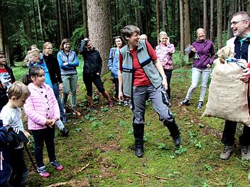 Alfred Sammetinger (r.) bekam von den Schülern und Försterin Heike Grumann einen Sack voller Kiefernzapfen als Geschenk.    Foto: Richard Sänger