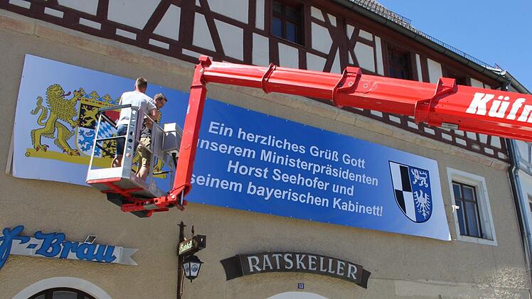 Mit einer Hebebühne installierten Mitarbeiter der Stadt ein extra für den Besuch der Politiker gefertigtes Plakat.  Foto: Andreas Schmitt