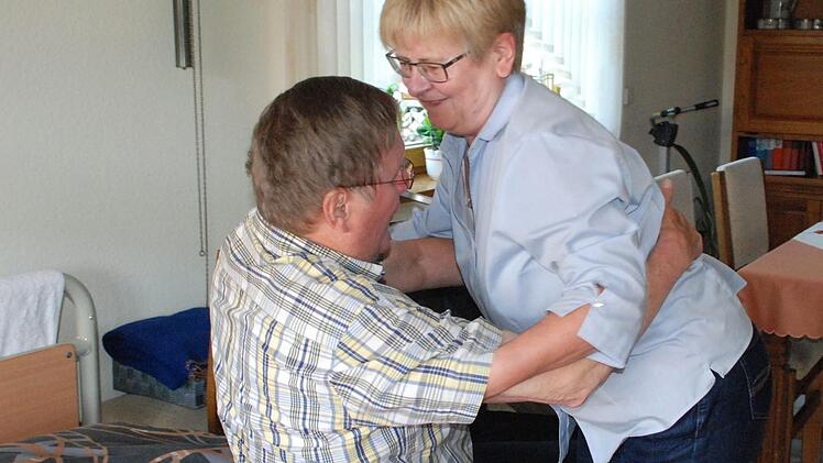 Schwerstarbeit für Gisela Dötschel: Sie hebt ihren Mann Gerhard vom Rollstuhl ins Bett. Fotos: Christiane Lehmann