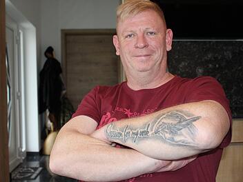 Oliver Fell wohnt mit seiner Lebensgefährtin im Ortskern von Oberleichtersbach. Seine Tattoos sind sein Markenzeichen. Foto: Julia Raab