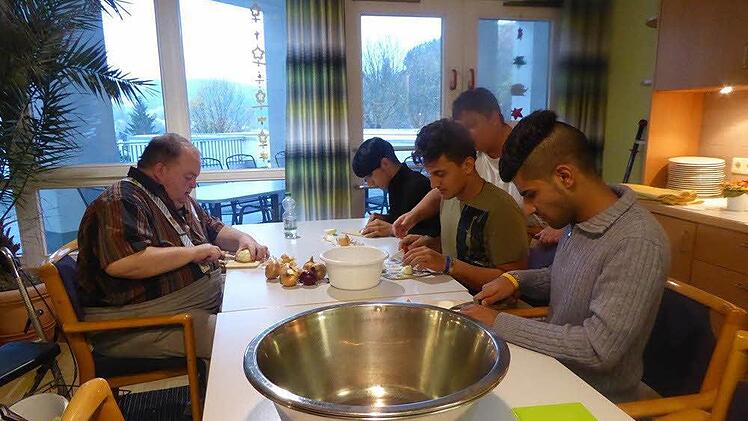 Gemeinsam bereiten (von links) Fredi Thomas, Ahmad, Rahman und Musa ein leckeres Büffet zu. Foto: Heike Schülein