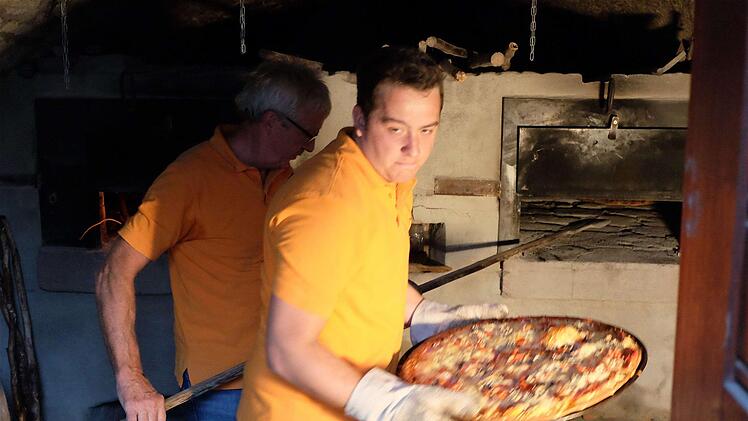 Heißer Job am Dorfbackofen. Die Pizzableche sind über 300 Grad heiß. Foto: Gerd Schaar