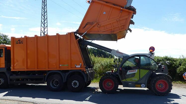 Landwirt Thomas Rausch half den Beschäftigten der Firma Simon, das abgelöschte Müllgut wieder einzuladen..  Foto: Klaus-Peter Wulf