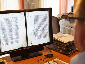 Dieter Vogler hat die Abschrift der Schenkungsurkunde von 716 aus dem "Liber aureus Epternacensis" auf dem Bildschirm. Foto: Arkadius Guzy