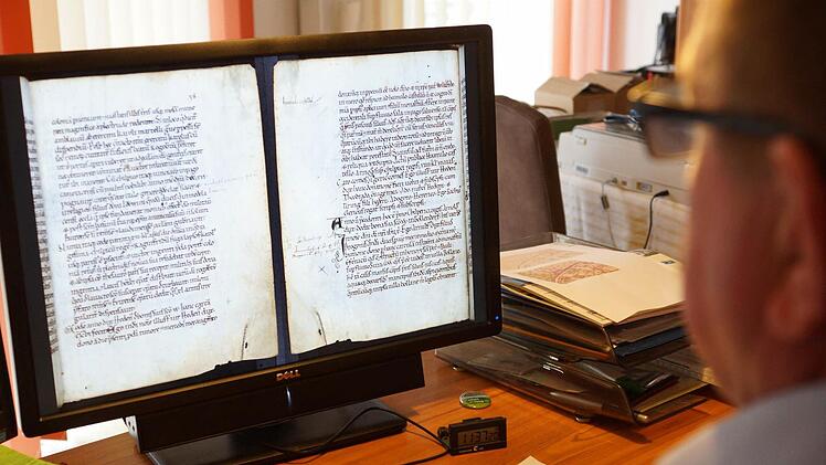 Dieter Vogler hat die Abschrift der Schenkungsurkunde von 716 aus dem "Liber aureus Epternacensis" auf dem Bildschirm. Foto: Arkadius Guzy
