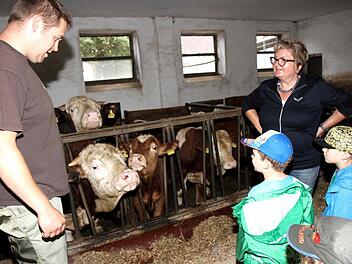 Florian Grau stellt den Kindern die Tiere auf seinem Bauernhof vor, rechts Kreisbäuerin Evi Derrer. Foto: Richard Sänger