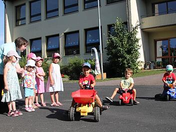 Feuern die Rennfahrer an: Kindergartenleiterin Heike Winter und ihre Mädels spielen Streckenposten für Moritz (von links), Leonhard und Paul, die sich vor dem Kindergarten Volkers ein Rennen liefern. Früher war der Platz der Pausenhof der Grundschule. Foto: Ulrike Müller