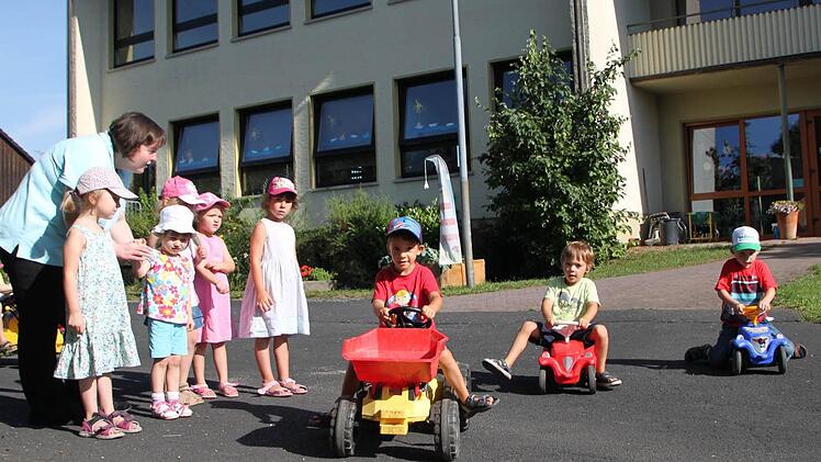 Feuern die Rennfahrer an: Kindergartenleiterin Heike Winter und ihre Mädels spielen Streckenposten für Moritz (von links), Leonhard und Paul, die sich vor dem Kindergarten Volkers ein Rennen liefern. Früher war der Platz der Pausenhof der Grundschule. Foto: Ulrike Müller