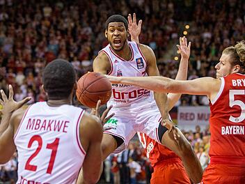 John Bryant (r) von München im Kampf um den Ball mit Trevor Mbakwe (l) und Ryan Thompson von Bamberg kämpfen um den Ball. Foto: Marc Müller/dpa