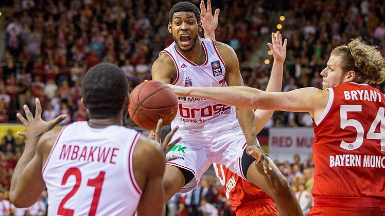 John Bryant (r) von München im Kampf um den Ball mit Trevor Mbakwe (l) und Ryan Thompson von Bamberg kämpfen um den Ball. Foto: Marc Müller/dpa