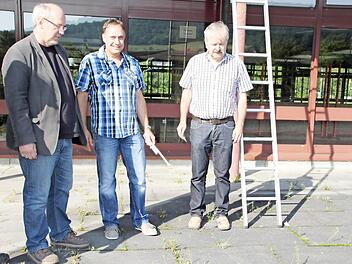 Karlheinz Lidak (links/ Firma Hofmann), Udo Schneider (Mitte/ Architekturbüro Richter) und Karl Heinz Weismantel begutachten den Pflasterboden vor der Halle, der 2014 erneuert wird.Foto: Sebastian Vogt