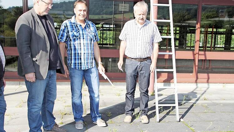 Karlheinz Lidak (links/ Firma Hofmann), Udo Schneider (Mitte/ Architekturbüro Richter) und Karl Heinz Weismantel begutachten den Pflasterboden vor der Halle, der 2014 erneuert wird.Foto: Sebastian Vogt