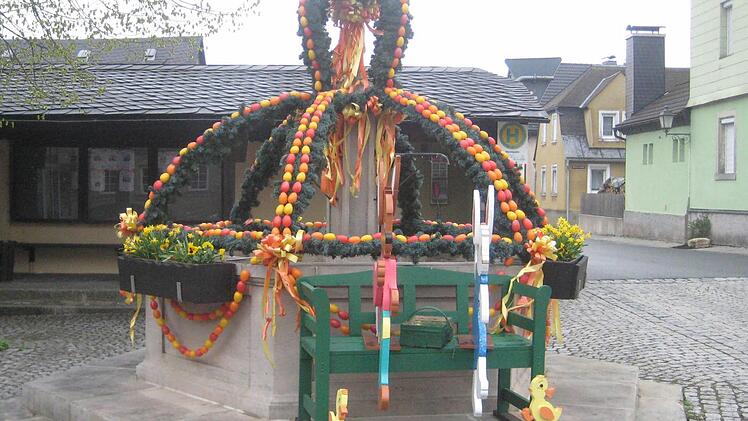 Rot, Gelb und Orange dominieren am Brunnen in Teuschnitz. Foto: Paul Hader