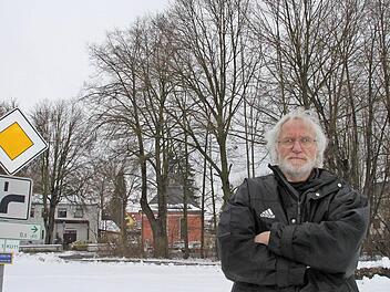 Veit Pöhlmann wehrt sich dagegen, dass die Bäume (im Hintergrund) für den millionenschweren Neubau fallen. Foto: Alexander Hartmann