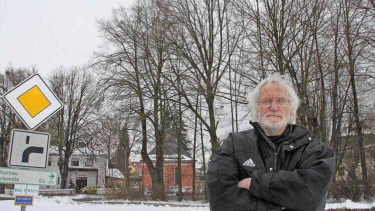 Veit Pöhlmann wehrt sich dagegen, dass die Bäume (im Hintergrund) für den millionenschweren Neubau fallen. Foto: Alexander Hartmann