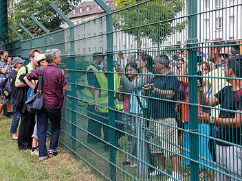 Szenen wie diese spielten sich am Donnerstag in der Bamberger Birkenalle ab. Flüchtlinge und Demonstranten gegen das Abschieblager sprechen durch den Zaun miteinander.   Fotos: Matthias Hoch