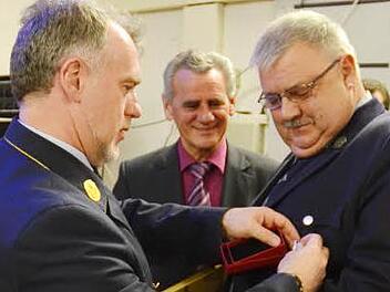Kreisbrandrat Joachim Ranzenberger (links) dekoriert die Uniform von Helmut Weidmann mit dem Ehrenzeichen des Freistaates Bayern in Gold für 40-jährige Dienstzeit. Die Urkunde überreichte Landrat Oswald Marr (Mitte). Fotos: K.-H. Hofmann