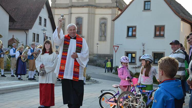 Feierliche Zeremonie: Pfarrer Edwin Erhard segnet den neu gestalteten Lindenrainplatz in Gauaschach.  Foto: Foto: Jana Keul