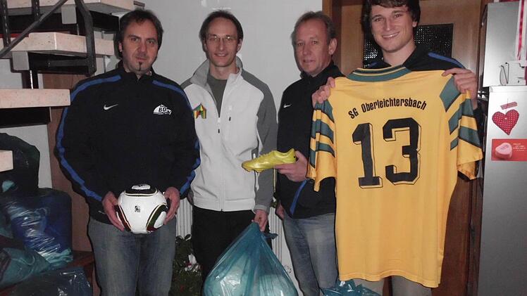 Der Vorsitzende der SG Oberleichtersbach, Ullrich Geppert (von links), übergibt die gespendete Fußballausrüstung an Kai Handel. Die beiden Abteilungsleiter Volker Enders und Christian Zirkelbach räumten zusammen das Sportheim aus und verpackten die Sachen. Foto: SG Oberleichtersbach