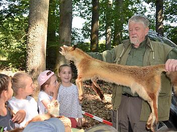 Josef Rüttiger, genannt Jäger Sepp, zeigt das Fell eines von ihm erlegten Fuchses. Die Kinder sind beeindruckt. Foto: Kathrin Kupka-Hahn