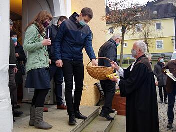 Pfarrer Johann Beck (rechts) beschenkte die Kirchenbesucher mit Obst und Süßem. Foto: Heike Schülein