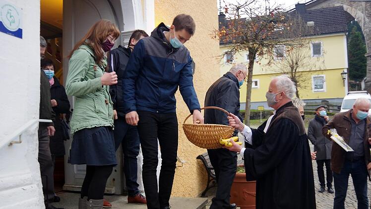 Pfarrer Johann Beck (rechts) beschenkte die Kirchenbesucher mit Obst und Süßem. Foto: Heike Schülein