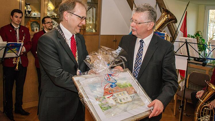 ... dem ehemaligen Bürgermeister Herbert Schneider (rechts) ein Bild des Künstlers Dieter Backert, welches das Küpser Rathaus zeigt. Foto: Marian Hamacher