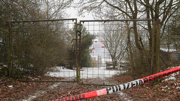 Absperrband der Polizei ist am 30.01.2017 vor der abgesperrten Zufahrt zu einem privaten Grundstück in der Nähe von Arnstein (Landkreis Main-Spessart) bei Würzburg angebracht. Nach dem Fund von sechs Toten in einer Gartenlaube in Unterfranken geben die Hintergründe des schrecklichen Geschehens weiter Rätsel auf. Foto: Daniel Karmann/dpa