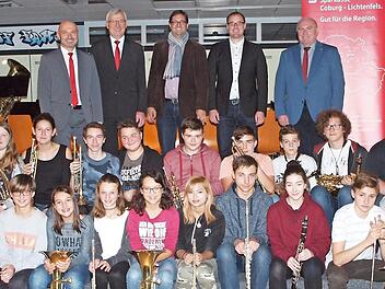 Die Sparkassenvertreter Oliver Hofmann und Walter Partheymüller, der Leiter der Bläserklasse, Florian Ebert, Projektmanager Andreas Pleichinger und Rektor Wolfgang Fischer (von links) sowie die Mitglieder des Schulorchesters freuten sich über die Aufnahme der Bläserklasse in das Musikförderprojekt.  Foto: Alfred Thieret