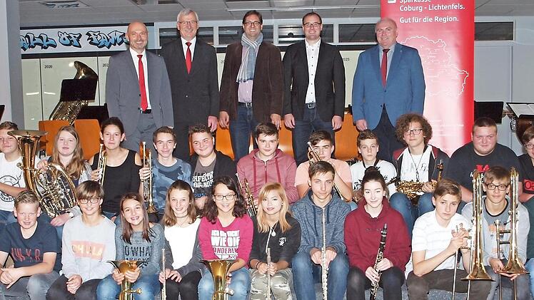 Die Sparkassenvertreter Oliver Hofmann und Walter Partheymüller, der Leiter der Bläserklasse, Florian Ebert, Projektmanager Andreas Pleichinger und Rektor Wolfgang Fischer (von links) sowie die Mitglieder des Schulorchesters freuten sich über die Aufnahme der Bläserklasse in das Musikförderprojekt.  Foto: Alfred Thieret