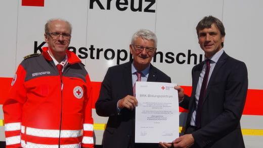 BRK-Pr&auml;sident Theo Zeller (Mitte) &uuml;berreicht die Ernennungsurkunde zum "BRK-Bildungszentrum" an BRK-Kreisgesch&auml;ftsf&uuml;hrer Roland Beierwaltes (r.) sowie Rettungsdienstleiter Martin Schmidt. hs