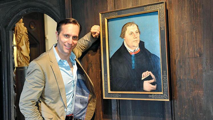 Falko Hönisch vor einem Luther-Porträt in den Coburger Kunstsammlungen.