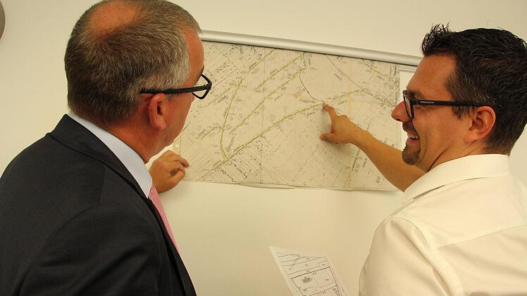 Andreas Sandwall, Bürgermeister von Bad Bocklet, (links) und Kämmerer Patrick Könen (rechts) sprechen über die Kanalbestandspläne. Auf den Plänen ist zu sehen, an welchen Plätzen die Kanäle im Untergrund entlang  laufen.  Foto: Anna Wentrock