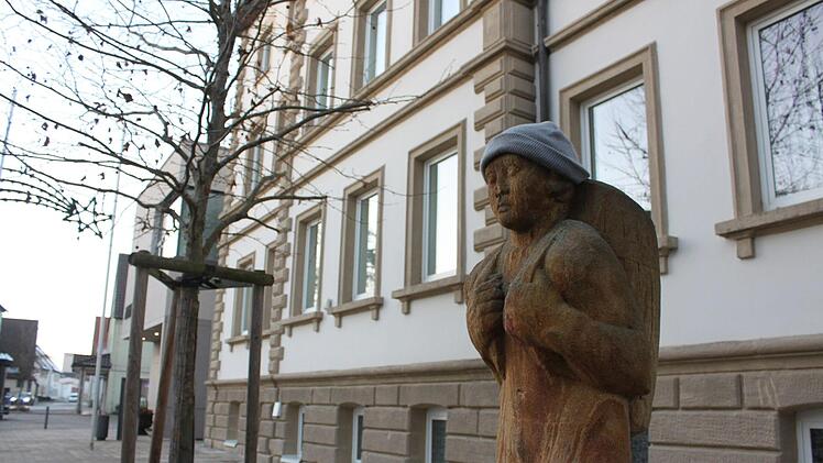 Korbmacherfigur (von jemandem mit einer Mütze versehen) vor dem Michelauer Rathaus. Wer hier der neue Chef wird, entscheiden die Bürger im April. Foto: Ramona Popp