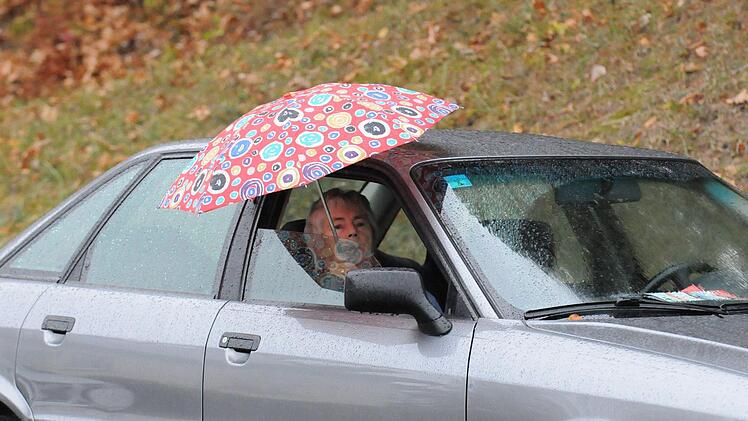 So wurde in Fuchsstadt bei Regen das Fu&szlig;ball-Derby gegen Euerbach geschaut: Auto nebens Feld gestellt und Schirm aufgespannt.ssp