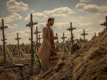 Terra X History: Kriegsverbrechen - Wenn der Staat zum Täter wird Nach dem russischen Überfall auf die Ukraine: Ein Priester bestattet die ukrainischen Zivilisten, die 2022 von russischen Soldaten in Butscha ermordet wurden.