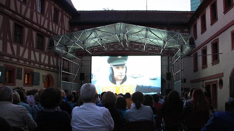 Die Zuschauer sitzen im Innenhof der Kaiserpfalz und sehen auf der Leinwand den Film "Winterkartoffelknödel". Foto: Luisa Hölzel