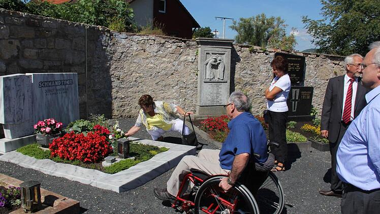 Rollstuhlfahrer Uwe Schmidt trauert mit seinen ehemaligen Schulkameraden am Grab des Rektors Josef Schwandtner.