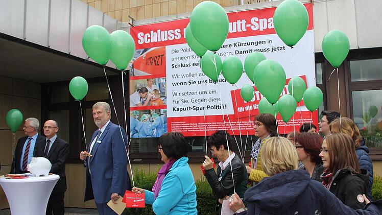Mit dem Plakat "Schluss mit dem Kaputt-Sparen", roten Karten und Luftballons (als Zeichen, dass den Krankenhäusern die Luft ausgeht) demonstrierten Mitarbeiter der Haßfurter Klinik gegen die geplante Krankenhausreform. Mit im Bild, von links: Haßfurts Bürgermeister Günther Werner, Landrat Wilhelm Schneider und der Vorstandsvorsitzende des Kommunalunternehmens Haßberg-Kliniken, Stephan Kolck.  Fotos: Klaus Schmitt
