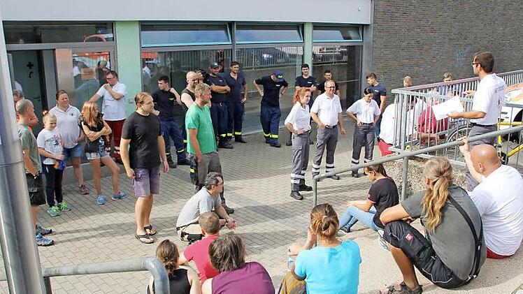 Es ist geschafft: Etwa 30 Helfer des Roten Kreuzes und des Technischen Hilfswerks haben am Samstag die Turnhalle West in Haßfurt für die Ankunft der Flüchtlinge vorbereitet. Sie stellten 60 Feldbetten auf. Danach trafen sie sich zur Schlussbesprechung vor der Turnhalle.