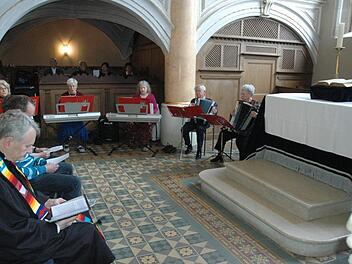 Pfarrer Ralph Utz (vorn) und die Gottesdienstbesucher lauschten den Klängen der "Crazy Ladies" (mit Keyboard und Akkordeon). Foto: Edwin Meißinger