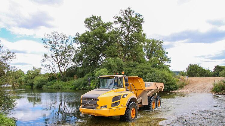 Für das laut Wasserwirtschaftsamt bayernweit einzigartige Projekt hat die Firma Porzner für die großen Lastwagen extra eine Furt durch den Main geschaffen.  Fotos: Sebastian Schanz