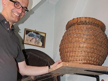 Stefan Andritscke in der Nische des Eberner Heimatmuseums,  in der historische Imkerutensilien präsentiert werden. Foto: Eckehard Kiesewetter