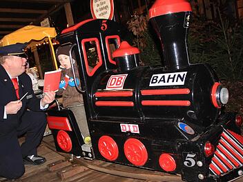 Peter Dauth schickt die erste Bahn auf die Strecke. Zuvor beschenkt er die Kinder noch mit Süßigkeiten und Malbüchern. Foto: Matthias Einwag